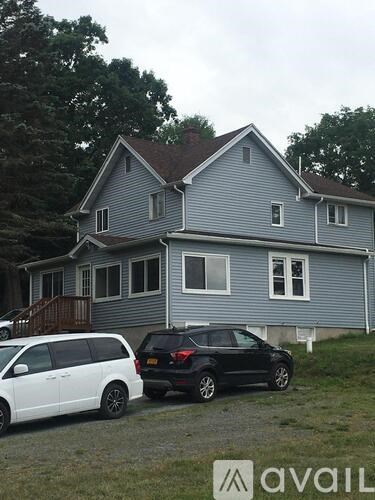 A house with a white car and a black car parked in front.