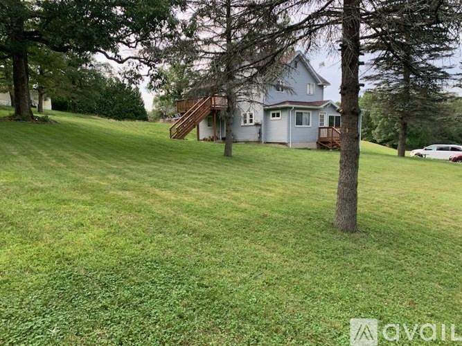 A house with a green lawn and a tree in front of it.