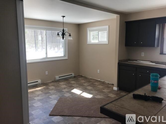 A room with a brown rug and a black countertop.