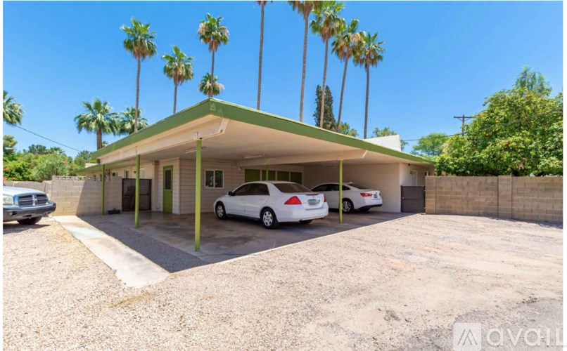 A car dealership with a green roof and white cars on display.