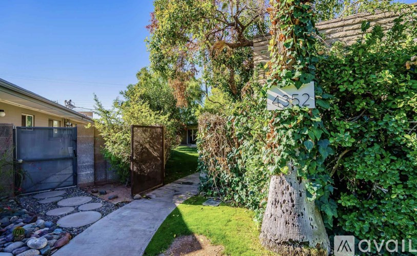 A house numbered 4352 is surrounded by greenery and a stone pathway.