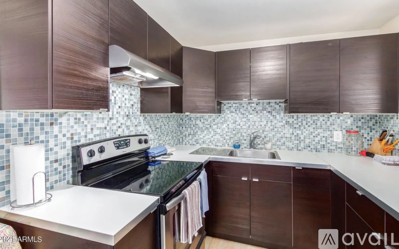 A kitchen with dark brown cabinets and a white counter top.