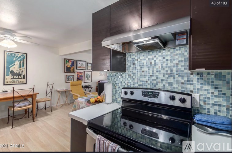 A kitchen with a black stove top oven and a tile backsplash.