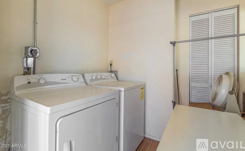 A white washing machine and dryer in a small laundry room.