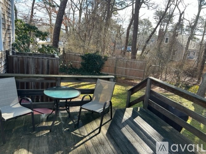 A wooden deck with a table and chairs.