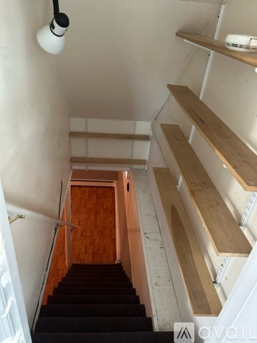 A staircase with wooden steps and a black carpeted runner.
