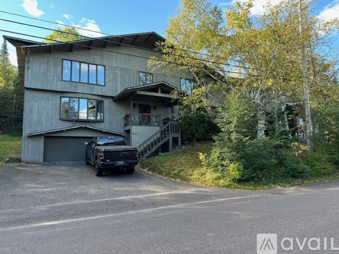 A house with a black truck parked in front.