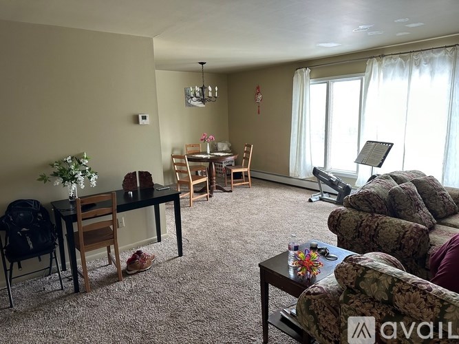 A living room with a couch, chairs, and a dining table.