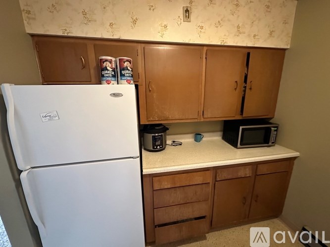 A kitchen with a white fridge and wooden cabinets.