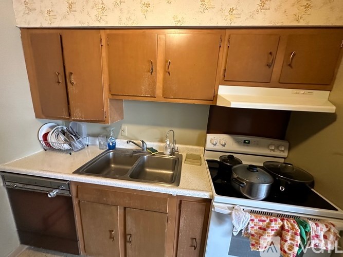 A kitchen with wooden cabinets and a stove top oven.