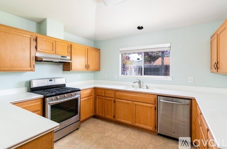 A kitchen with wooden cabinets and a stove top oven.