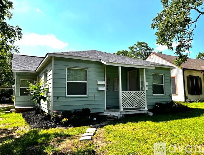 A small house with a porch and a small garden in front.