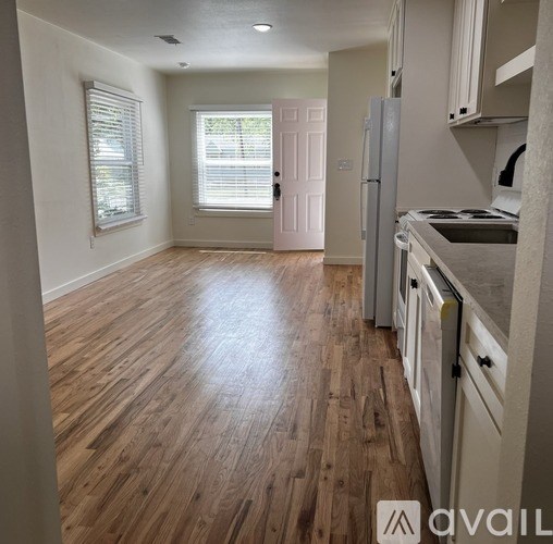 A kitchen with wooden floors and white appliances.