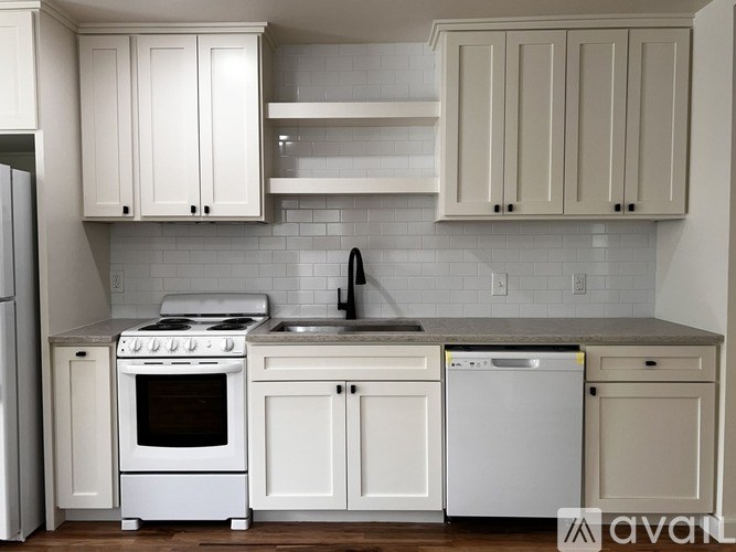 A kitchen with white appliances and cabinets.
