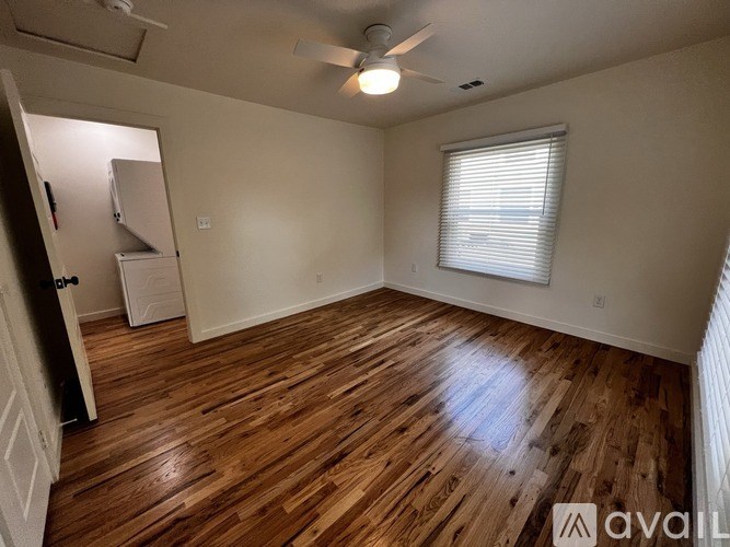 A room with wooden flooring and a ceiling fan.