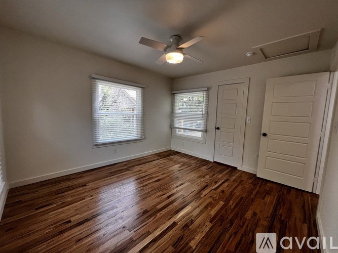 A room with wooden flooring and a ceiling fan.