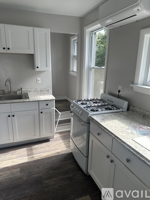 A kitchen with white cabinets and a stove top oven.