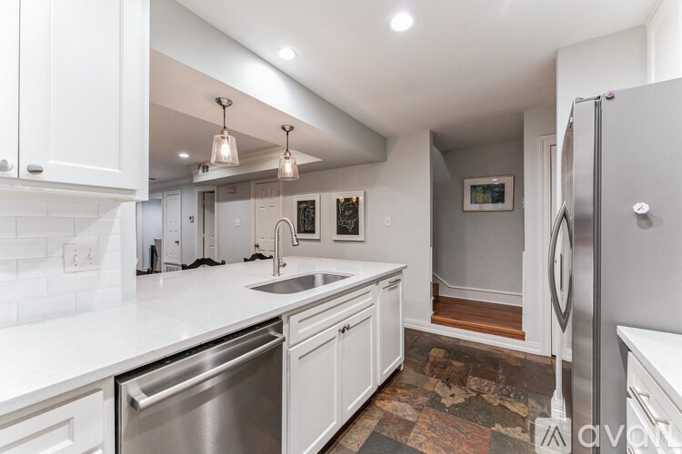 A modern kitchen with white cabinets and a tiled backsplash.