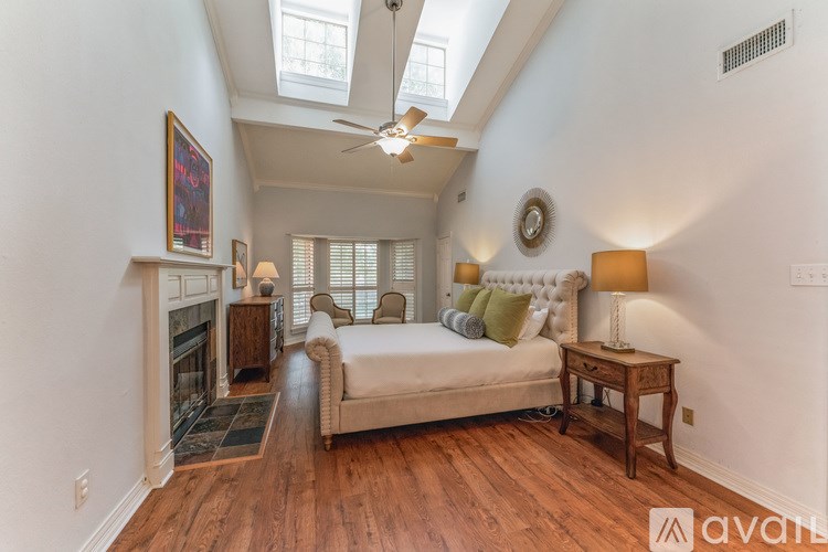 A bedroom with a bed, a table, and a fireplace.