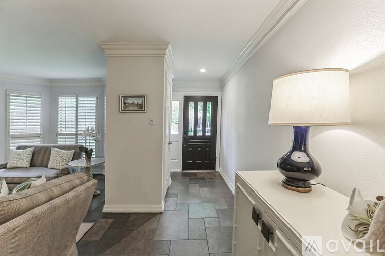 A well-lit living room with a couch, a lamp, and a picture on the wall.