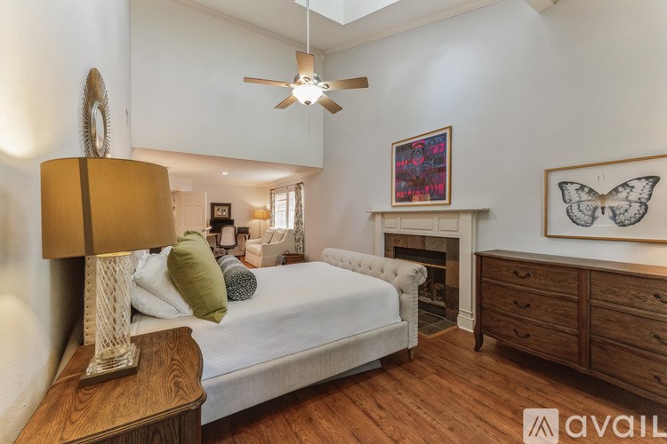 A bedroom with a bed, a lamp, and a painting on the wall.