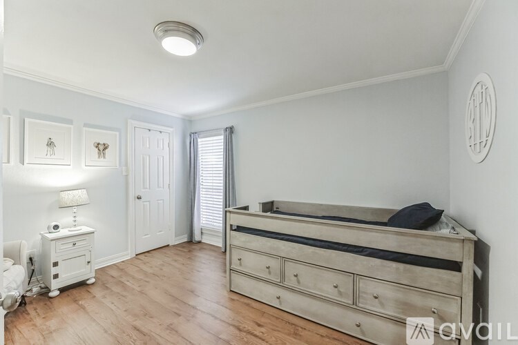 A bedroom with a bed, nightstand, and lamp.