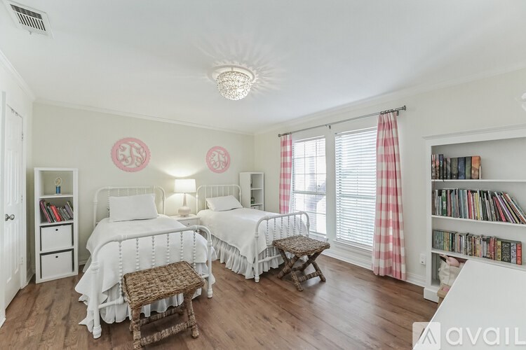 A bedroom with two beds, a bench, and a bookshelf.