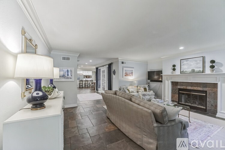 A living room with a grey couch and a fireplace.