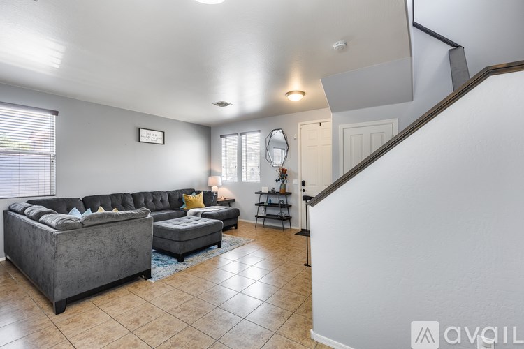 A living room with a grey couch and a grey ottoman.