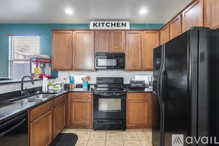 A kitchen with wooden cabinets and black appliances.