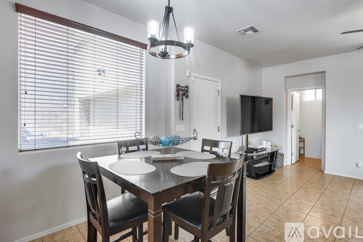 A dining room with a table set for two and a television in the corner.