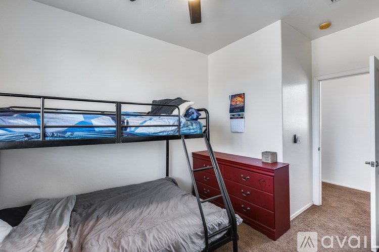 A bedroom with a bunk bed and a red dresser.