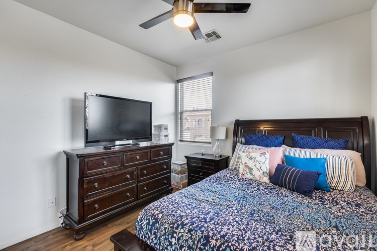 A bedroom with a bed, dresser, and television.