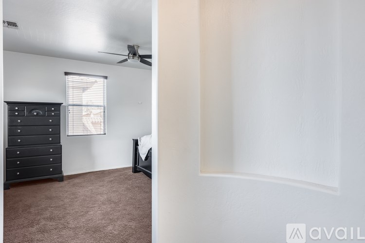 A room with a ceiling fan and a window with blinds.