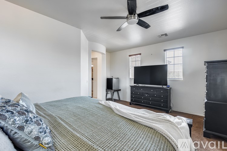 A bedroom with a bed, dresser, and television.