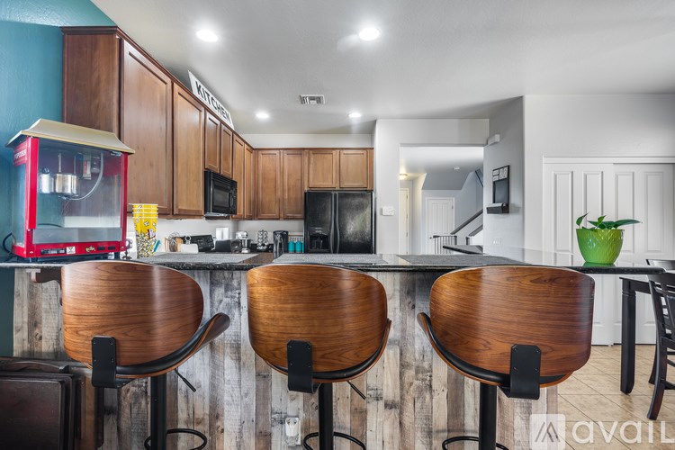 A kitchen with wooden bar stools and a counter.