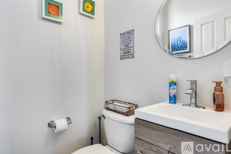 A bathroom with a toilet, sink, and mirror.