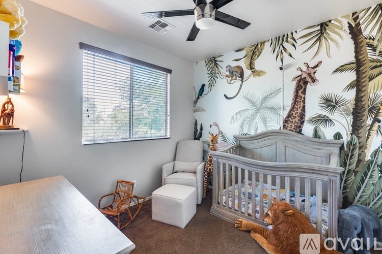 A baby room with a giraffe and a lion on the wallpaper.