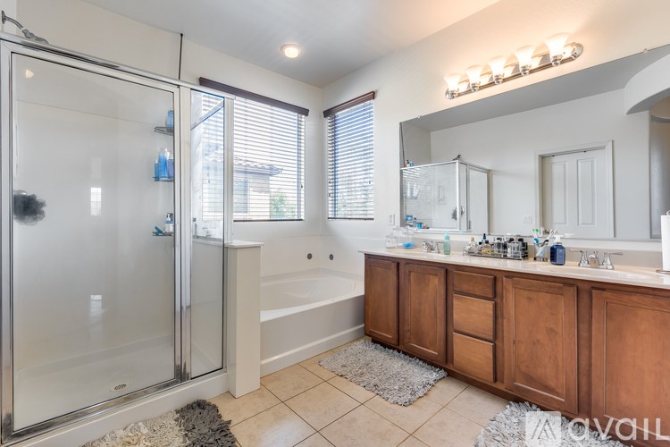 A bathroom with a glass shower door and a white bathtub.