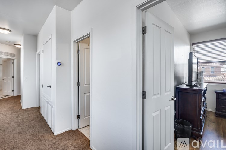A room with a white door and a brown carpet.