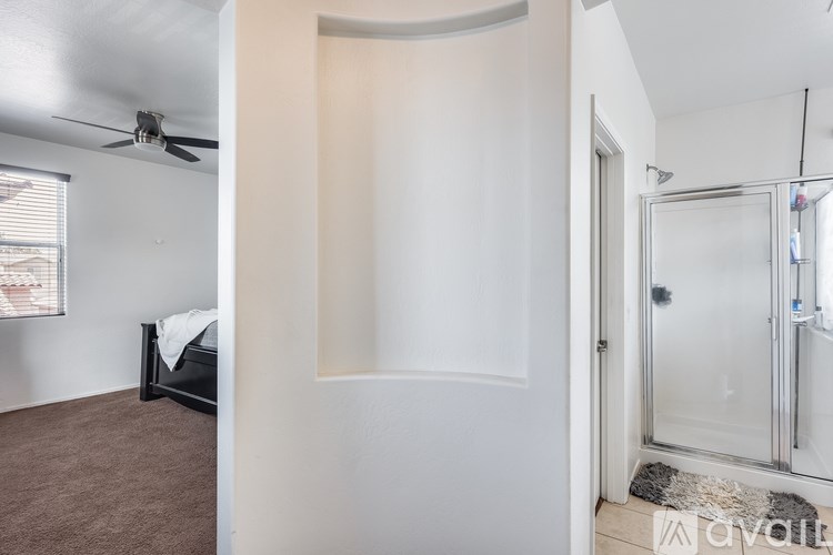 A bedroom with a bed, carpet, and a glass door.