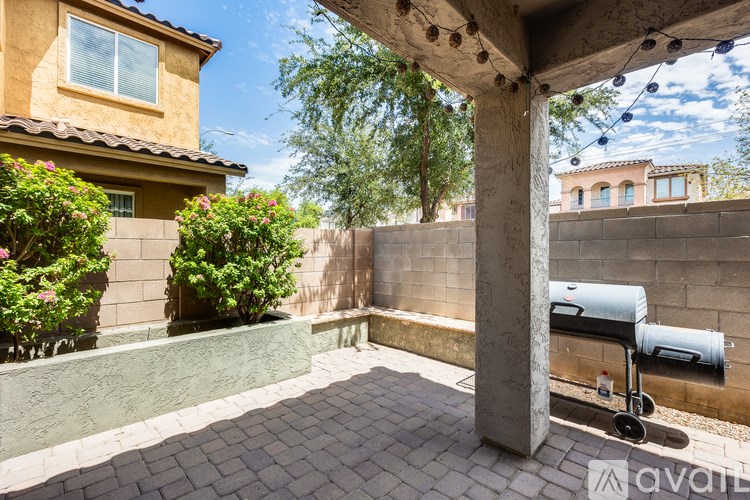 A patio with a table and chairs under a roof.