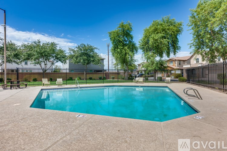 A swimming pool surrounded by a fence and trees.