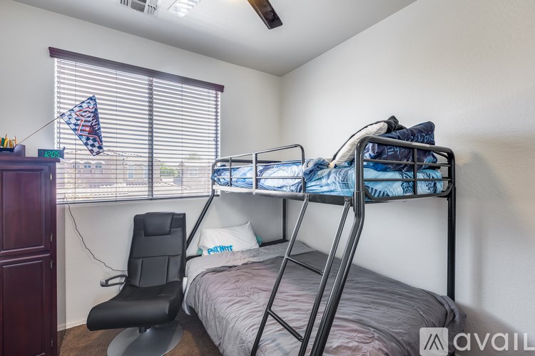 A bedroom with a bunk bed and a chair.