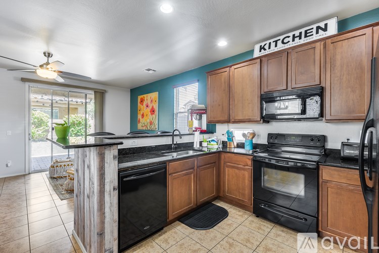 A kitchen with wooden cabinets and black appliances.