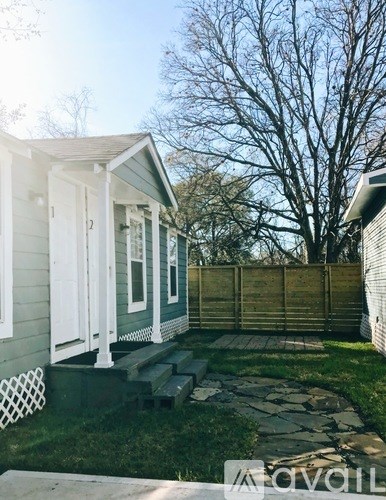 A small house with a porch and a fence.
