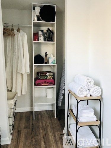 A white closet with a white shelf and a white chair.