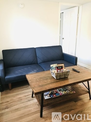 A blue couch with a basket on a wooden coffee table in a room.
