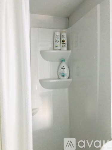 A white refrigerator with three bottles of milk on the shelf.