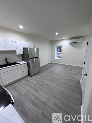 A kitchen with white cabinets and a grey floor.